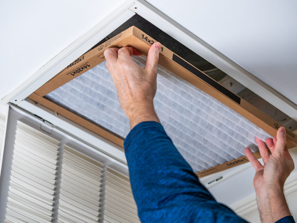 HVAC technician replacing a home air filter in Santa Barbara